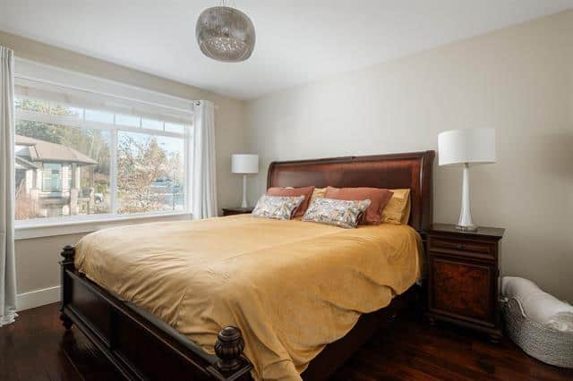 - A cozy bedroom with a large window, modern decor, and a comfortable king-sized bed showcasing Orca Realty Inc. property listings in Canada.