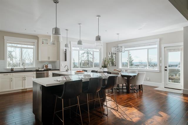 Bright modern kitchen with large windows, white cabinetry, and a central island, perfect for family living and entertaining in Vancouver.
