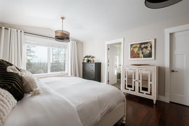 Beautiful modern bedroom interior with large window, cozy bedding, and stylish decor, ideal for homebuyers or real estate listings in the Vancouver area.