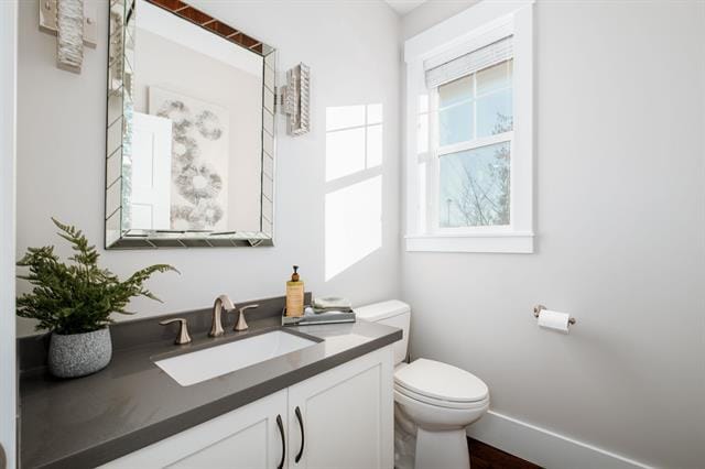 Modern bathroom with white walls, grey countertop, and natural light, featuring a sleek vanity, mirror, and toilet, perfect for Vancouver home living.