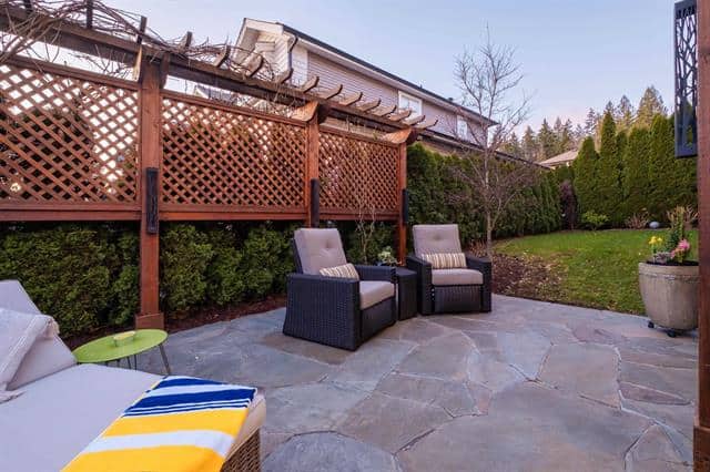 Cozy backyard patio with outdoor furniture and lush greenery, perfect for relaxation and entertaining in Victoria BC. Well-maintained outdoor living space by Orca Realty Inc.