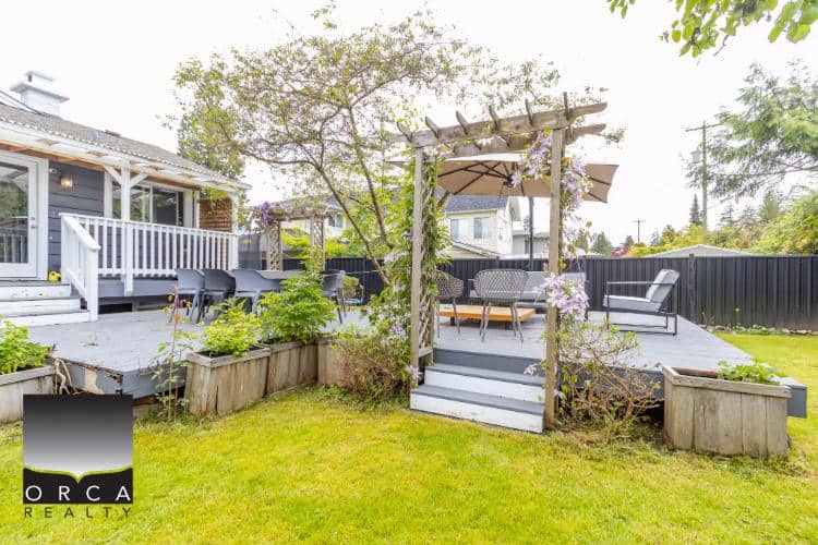 Cozy outdoor backyard patio with seating area and garden, perfect for relaxing and entertaining in a residential home in Vancouver, BC.