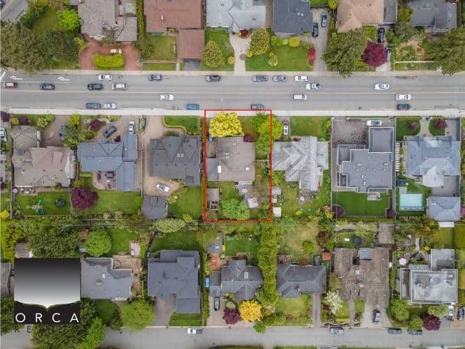 Aerial view of a residential property for sale in a peaceful neighbourhood with lush greenery, surrounded by similar homes, showcasing the ideal real estate opportunity in Vancouver, BC.