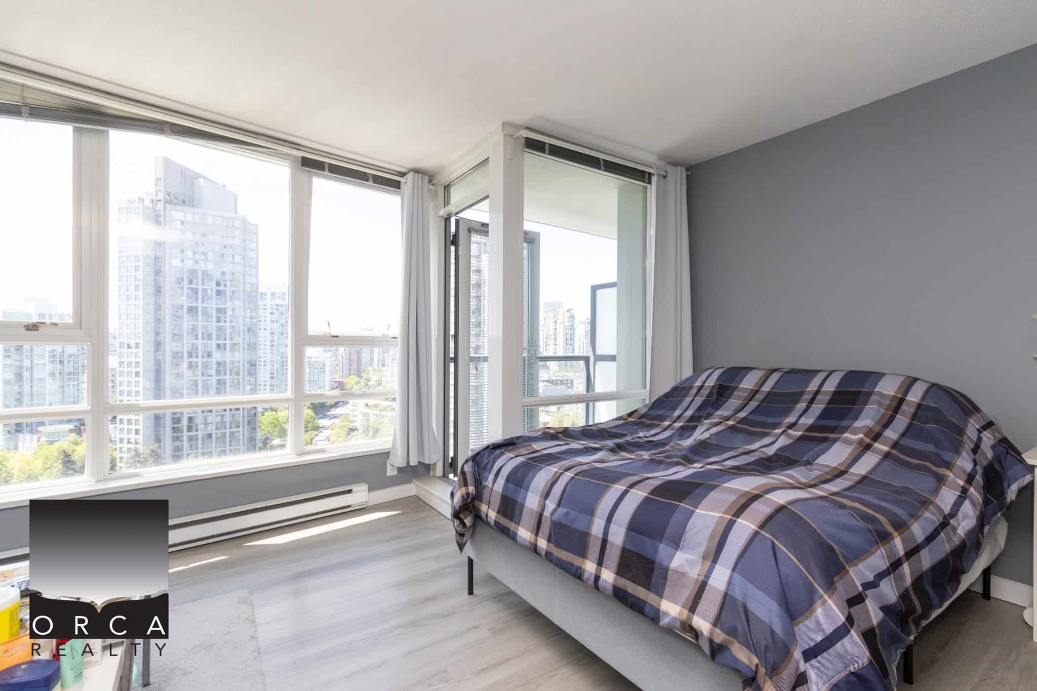 Bright modern city view bedroom in downtown Vancouver, featuring large windows, natural light, and contemporary decor, perfect for urban living and luxury real estate in BC.