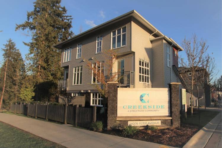 Modern multi-family residential building at Creekside in Victoria, BC, featuring contemporary architecture and lush landscaping, offered by Orca Realty Inc.
