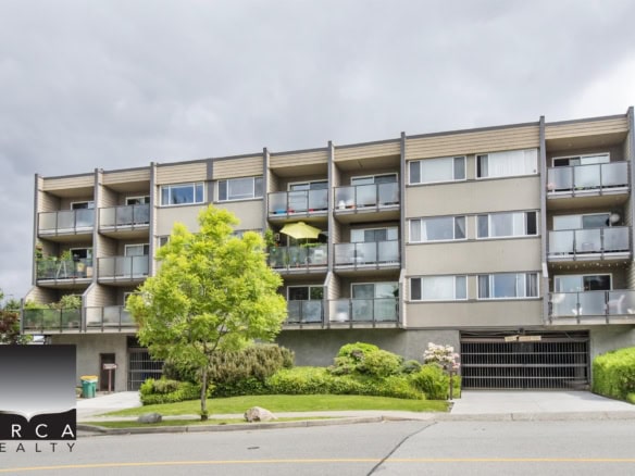 Modern multi-unit residential building with green landscaped surroundings and accessible parking, ideal for Vancouver real estate investment and rental properties.