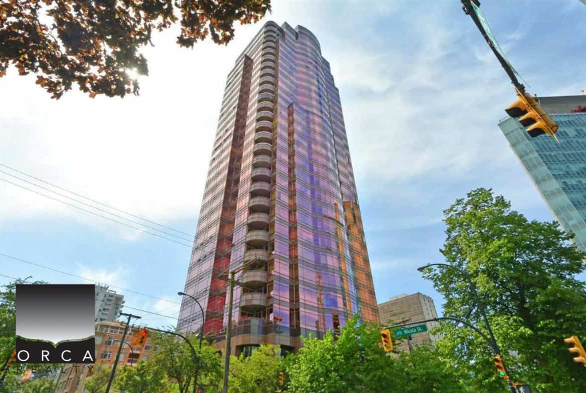 Modern high-rise condo building in downtown Vancouver with glass facade reflections, city skyline views, and lush greenery surrounding the area, showcasing upscale urban living.