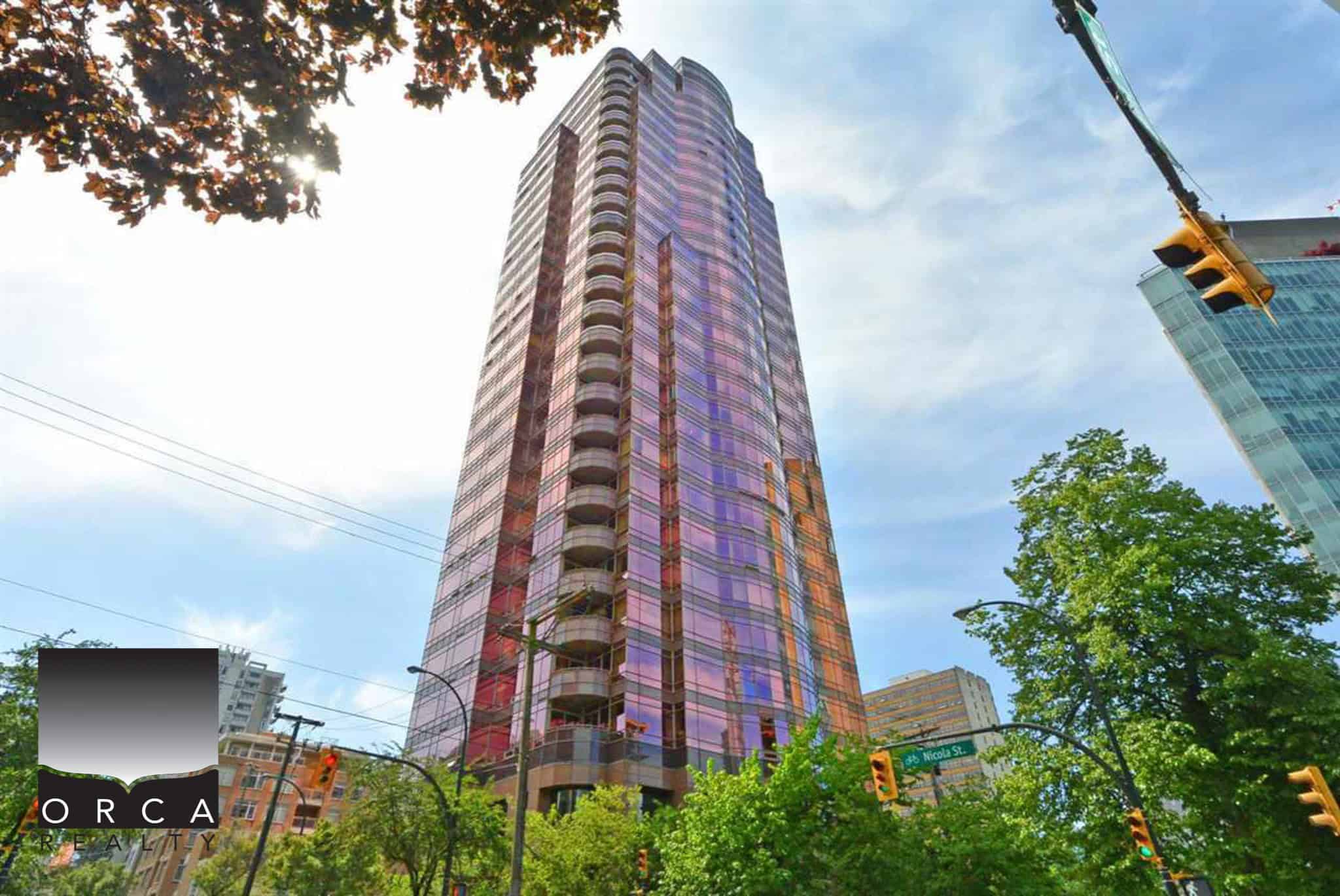 Modern high-rise condo building in downtown Vancouver with glass facade reflections, city skyline views, and lush greenery surrounding the area, showcasing upscale urban living.
