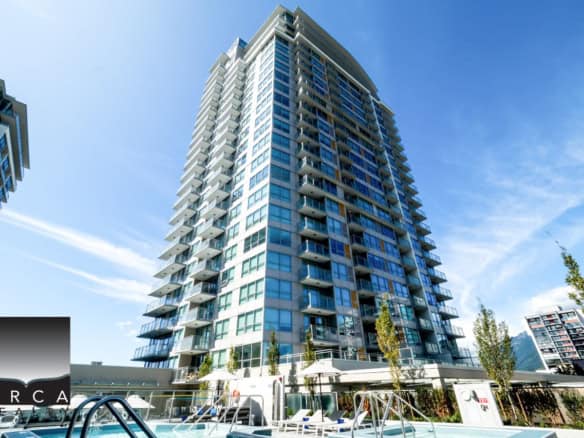 Modern waterfront high-rise condo building with balconies and glass exterior, located in Vancouver's vibrant downtown for luxury living and investment opportunities.