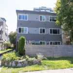 Contemporary multi-family residential building with modern design, large windows, and landscaped front yard, showcasing Vancouver real estate opportunities and investment potential.