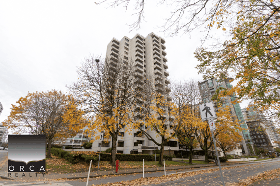 Modern high-rise residential building in Vancouver with autumn foliage and city skyline in background, representing luxury real estate and property services by Orca Realty Inc.
