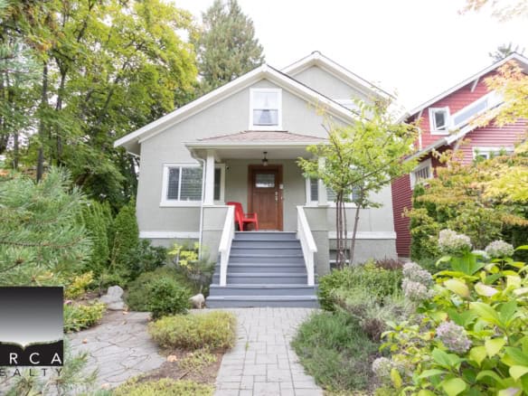 Charming Vancouver home exterior with lush landscaping, colorful garden, and inviting front steps, showcasing Orca Realty's premium real estate services in British Columbia.