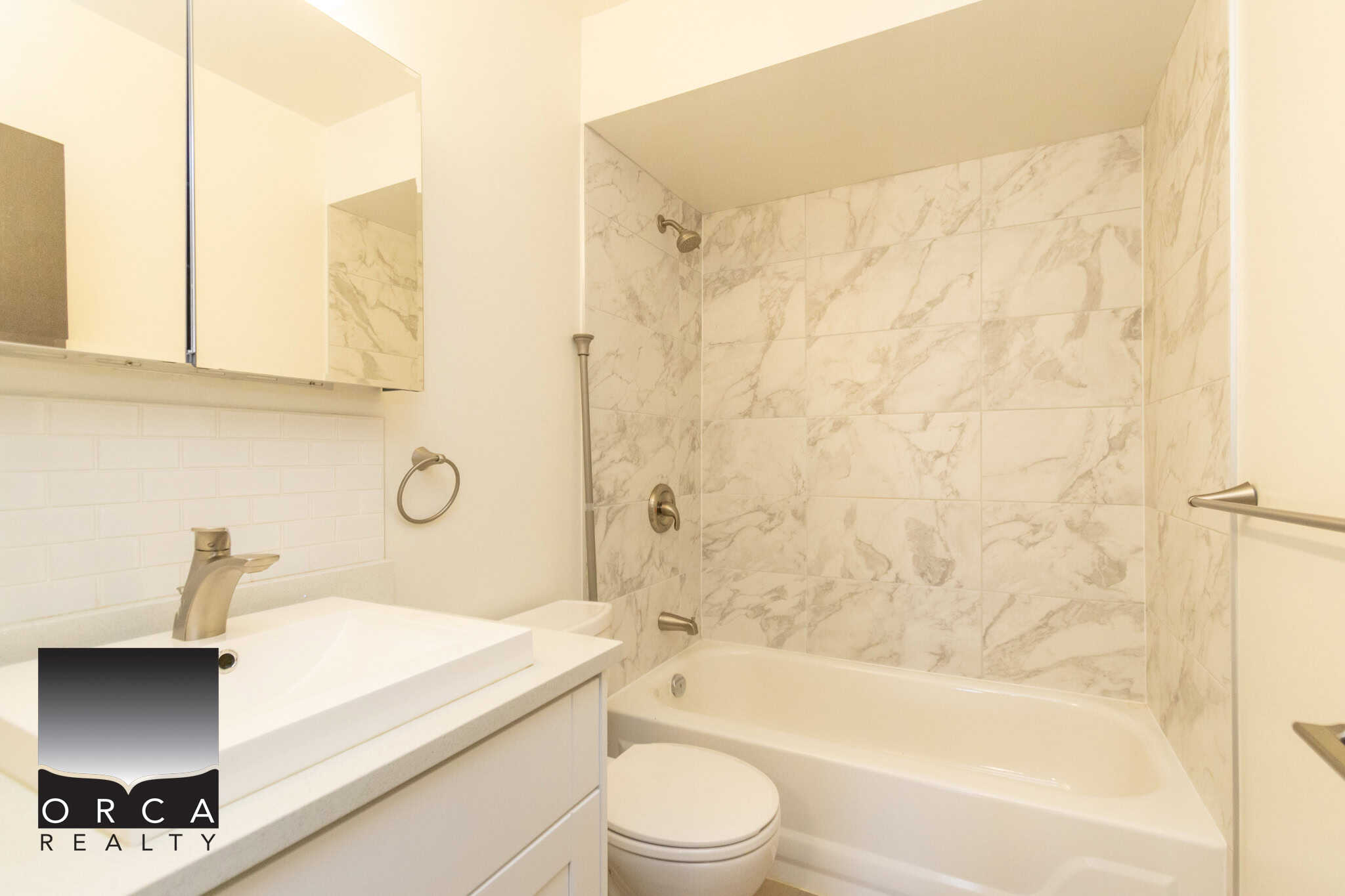 Bright modern bathroom with marble tile accents, white vanity, and contemporary fixtures, ideal for Toronto homebuyers seeking elegant and functional interiors.