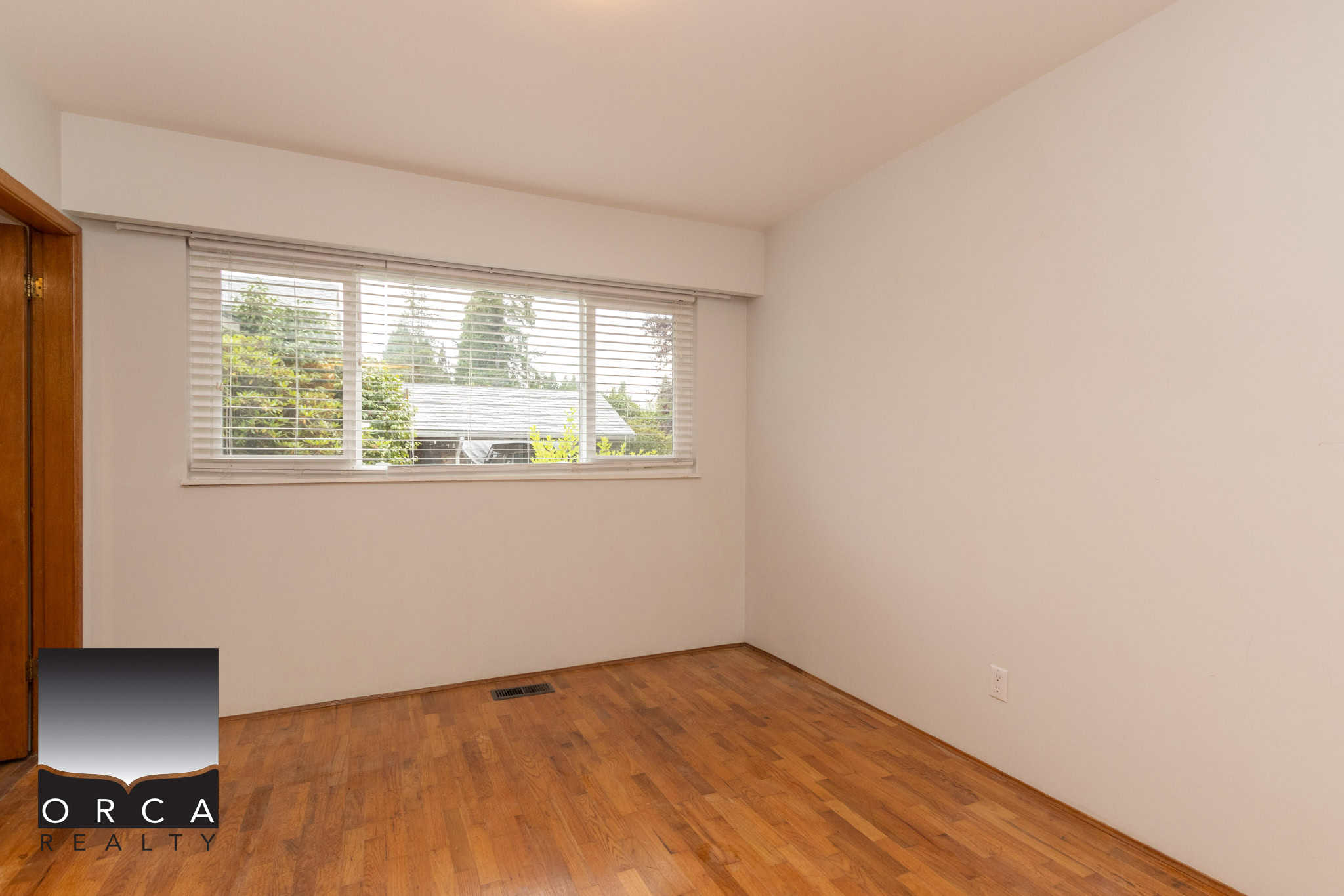 10 Bright empty room with hardwood flooring and large window, ideal for home staging, fixed blinds, natural light, Vancouver homes, real estate listings, property for sale, residential interior.