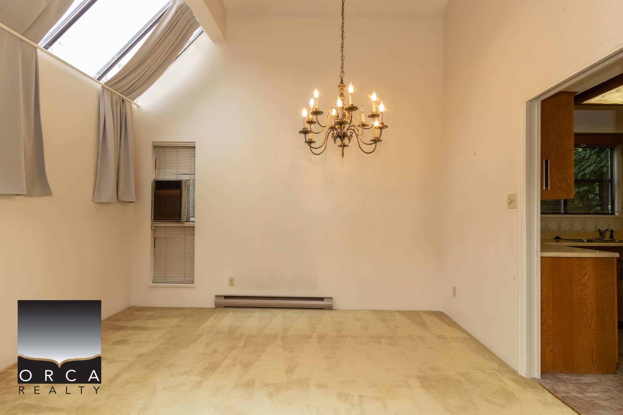 Bright dining area with high vaulted ceiling, elegant chandelier, large skylight, and neutral decor, ideal for Ottawa homebuyers seeking modern living spaces.