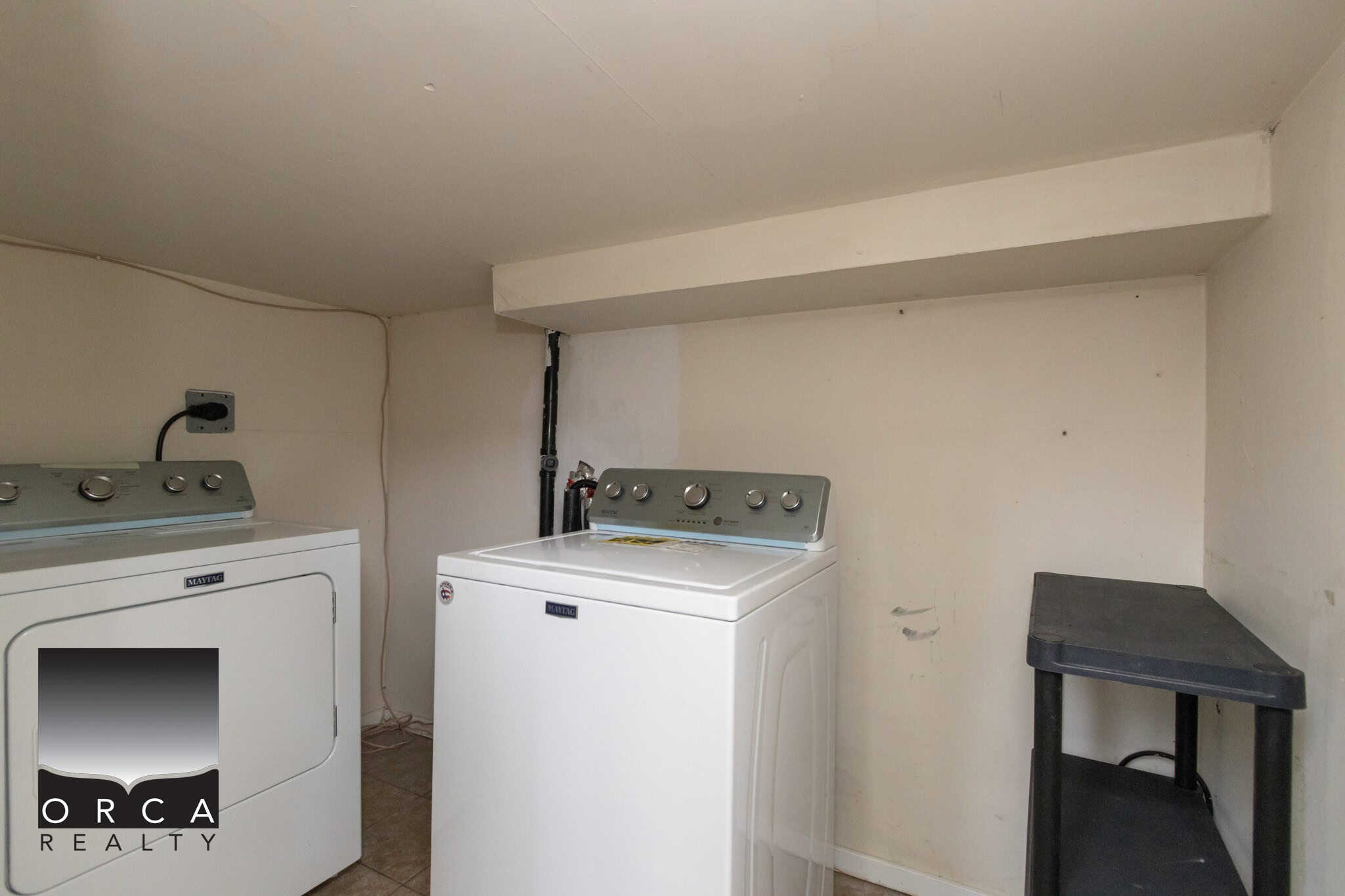 Quiet laundry area with side-by-side washer and dryer in a basement laundry room, featuring practical storage and utility space, perfect for all your laundry needs.