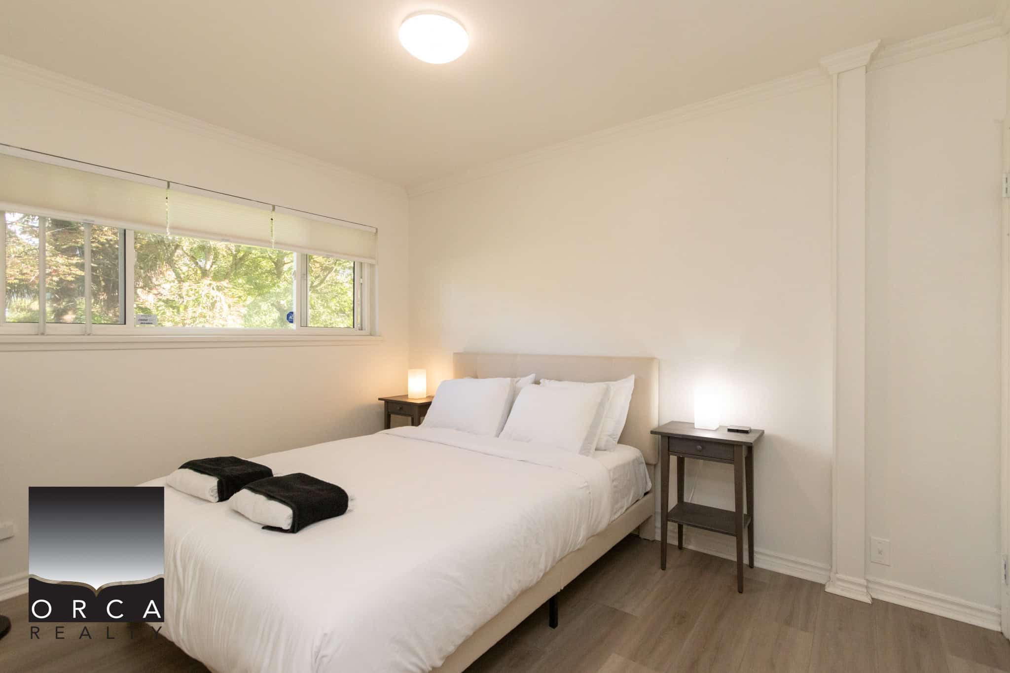 10 Bright Airbnb bedroom with large window, cozy bedding, and minimalist decor, perfect for Vancouver vacation rentals and short-term stays.