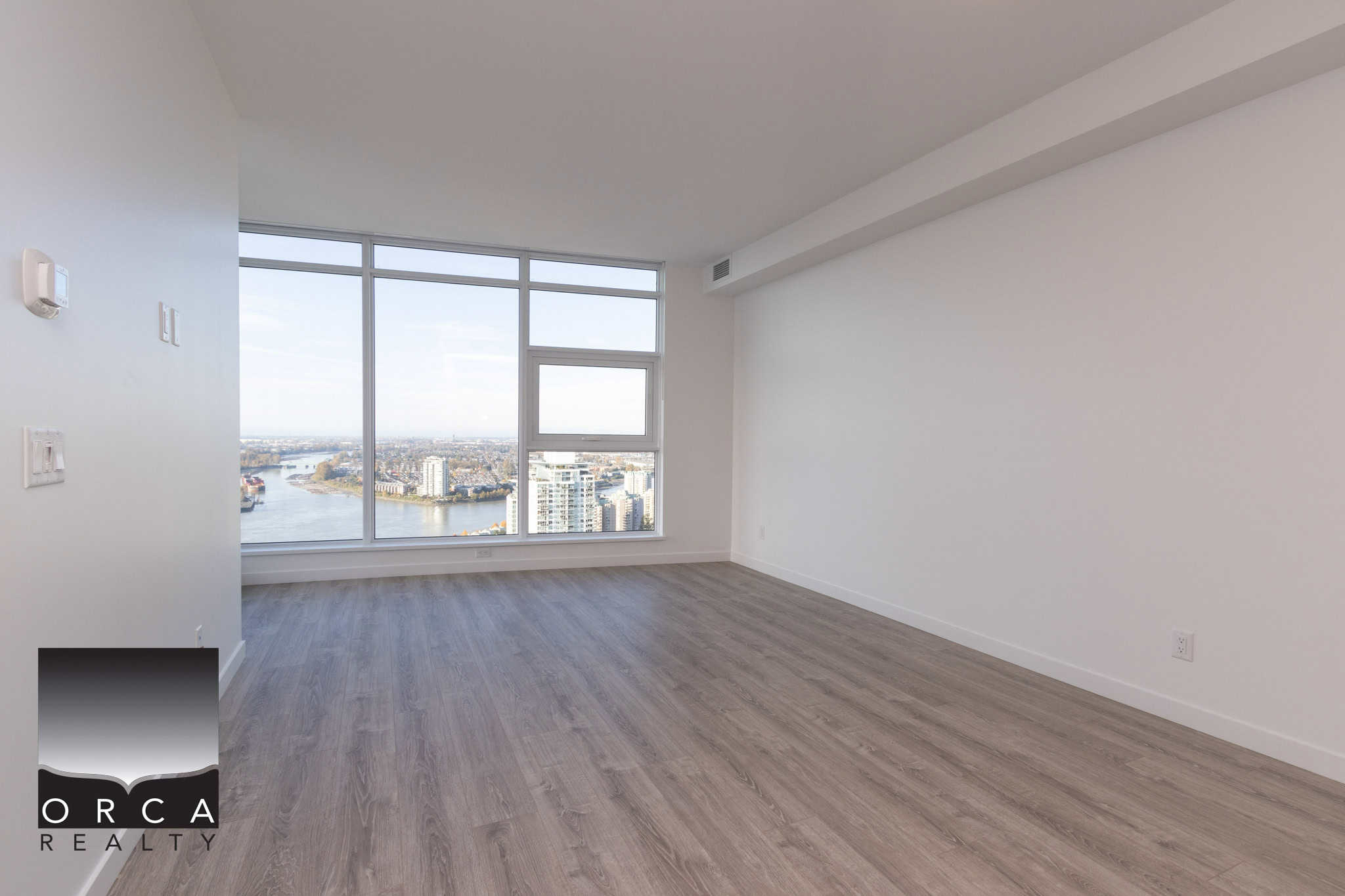 10 Bright modern high-rise apartment with panoramic river and city views in Vancouver, BC. Spacious, open-plan living area with large windows and contemporary finishes, ideal for urban living.