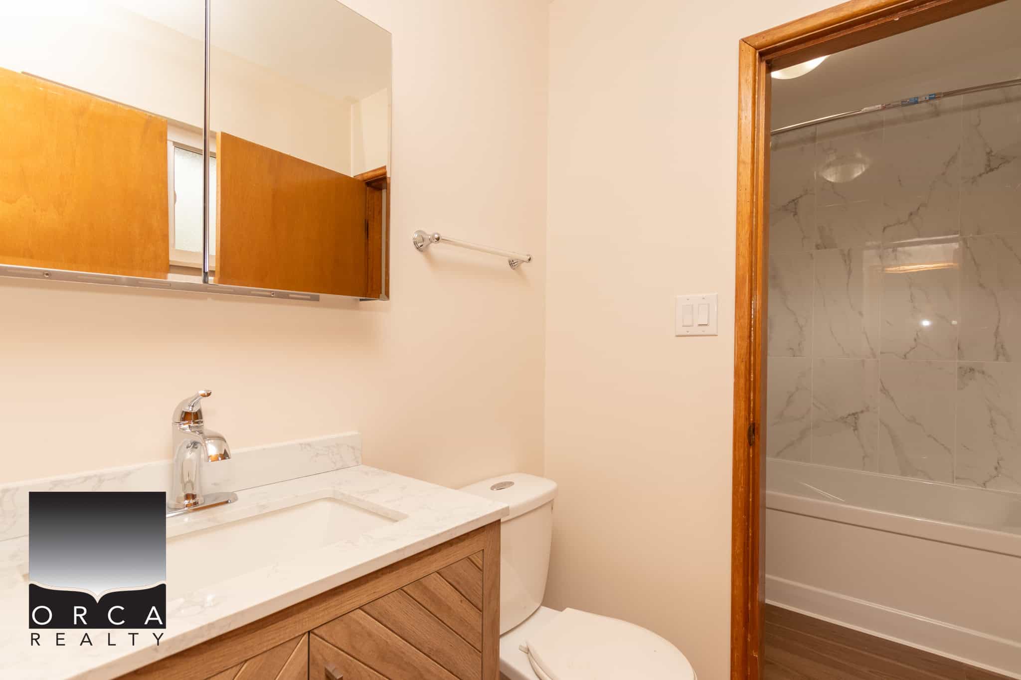11 Bright modern bathroom with wood accents, marble countertops, and a walk-in shower, ideal for Vancouver real estate buyers seeking stylish, updated homes in the ORCA Realty portfolio.