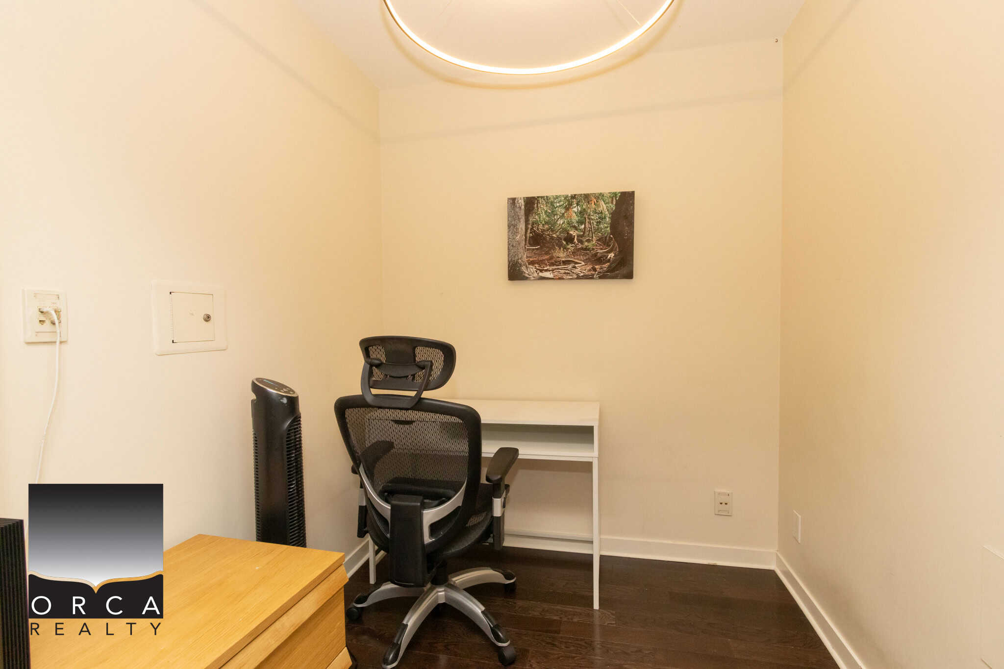 Modern home office space with ergonomic chair, white desk, and minimalist decor, ideal for remote work or study, featuring warm lighting and clean design.