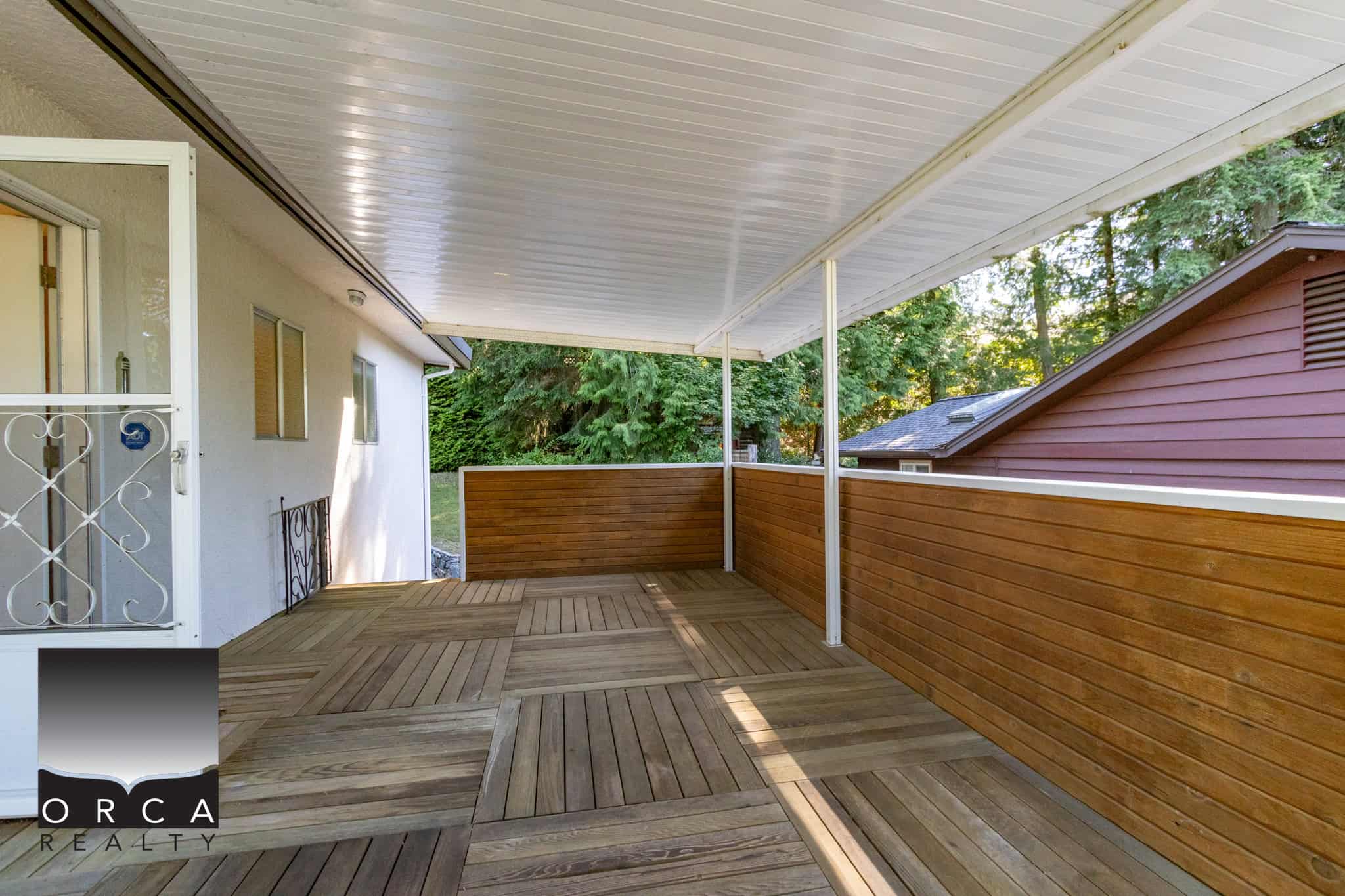 Spacious wooden deck on a residential balcony with privacy fencing, ideal for outdoor living and entertaining in a peaceful neighbourhood.