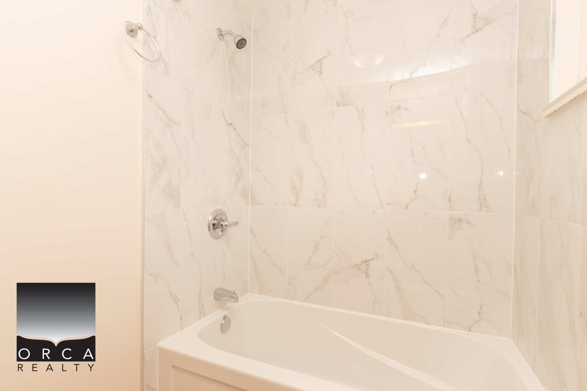 12 Beautiful modern bathroom with marble tile walls and a sleek bathtub, featuring contemporary fixtures perfect for luxury home interiors.