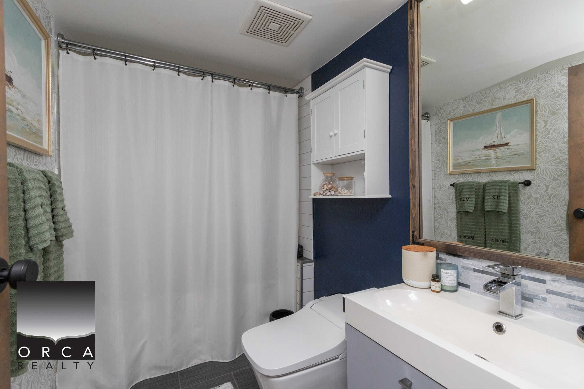 Modern bathroom with navy accent wall, white vanity, and decorative shell accents, perfect for Vancouver Island homes and real estate in Comox Valley or Campbell River.