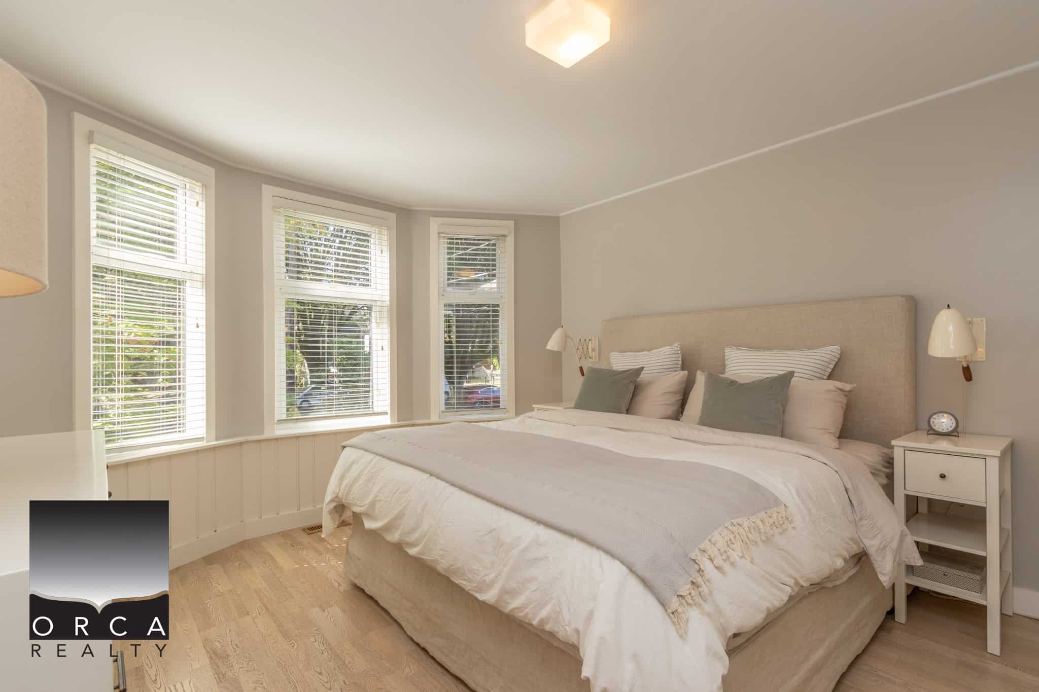 14 Spacious bedroom with large bay windows, neutral decor, and cozy bedding in a modern Vancouver home. Perfect for relaxing or enjoying natural light.