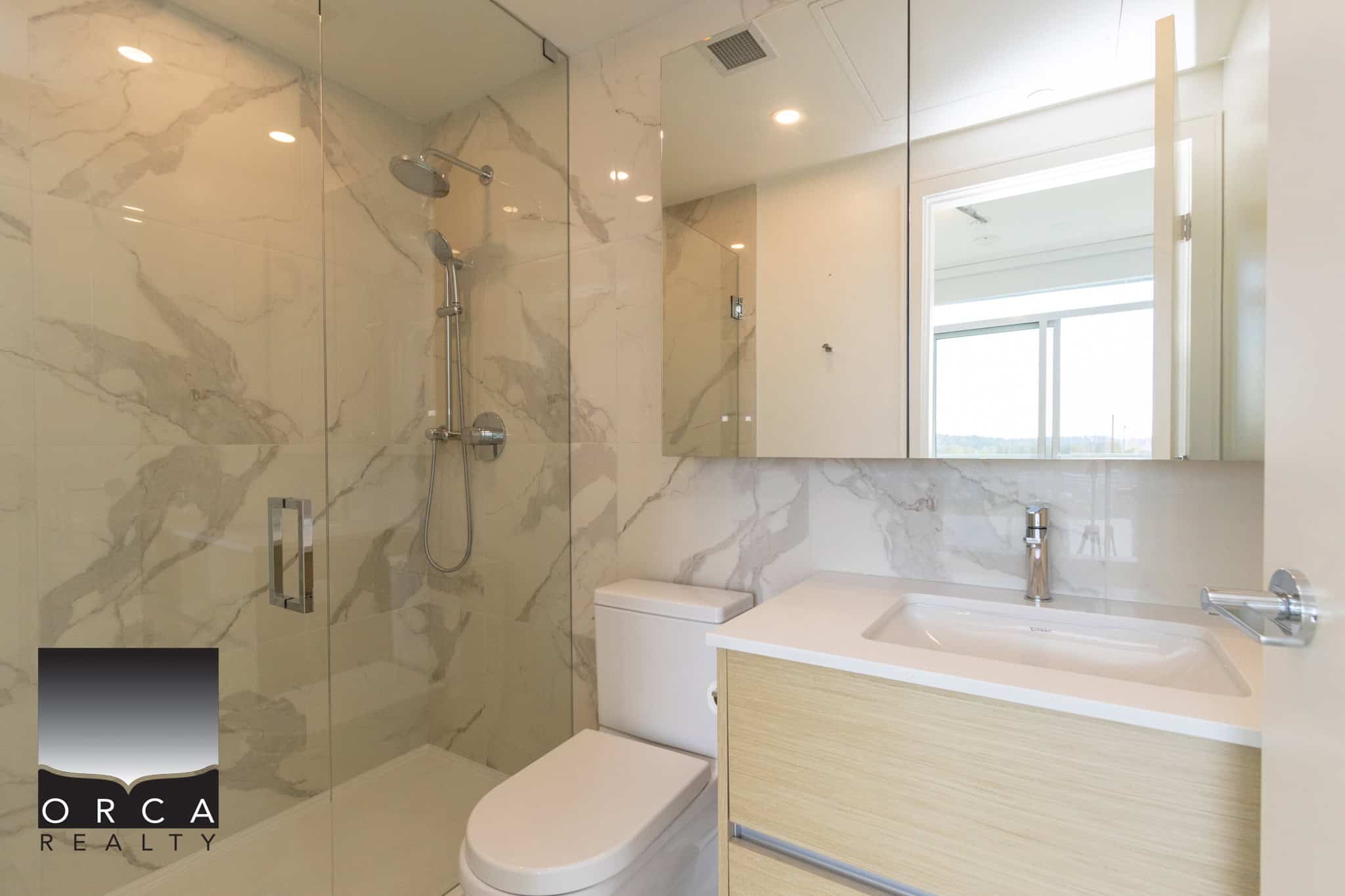 Luxury modern bathroom with marble tiles, walk-in shower, sleek vanity, and ample natural light, showcasing upscale interior design and high-end finishes in a contemporary home near Vancouver, BC.