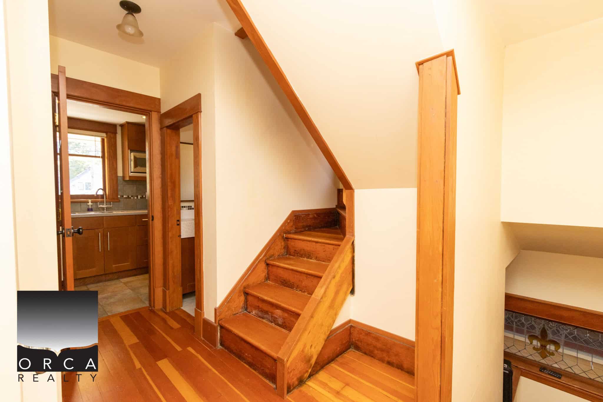 Cozy wooden staircase inside a charming home, leading to upper levels with natural wood finishes and classic interior design, perfect for family living.