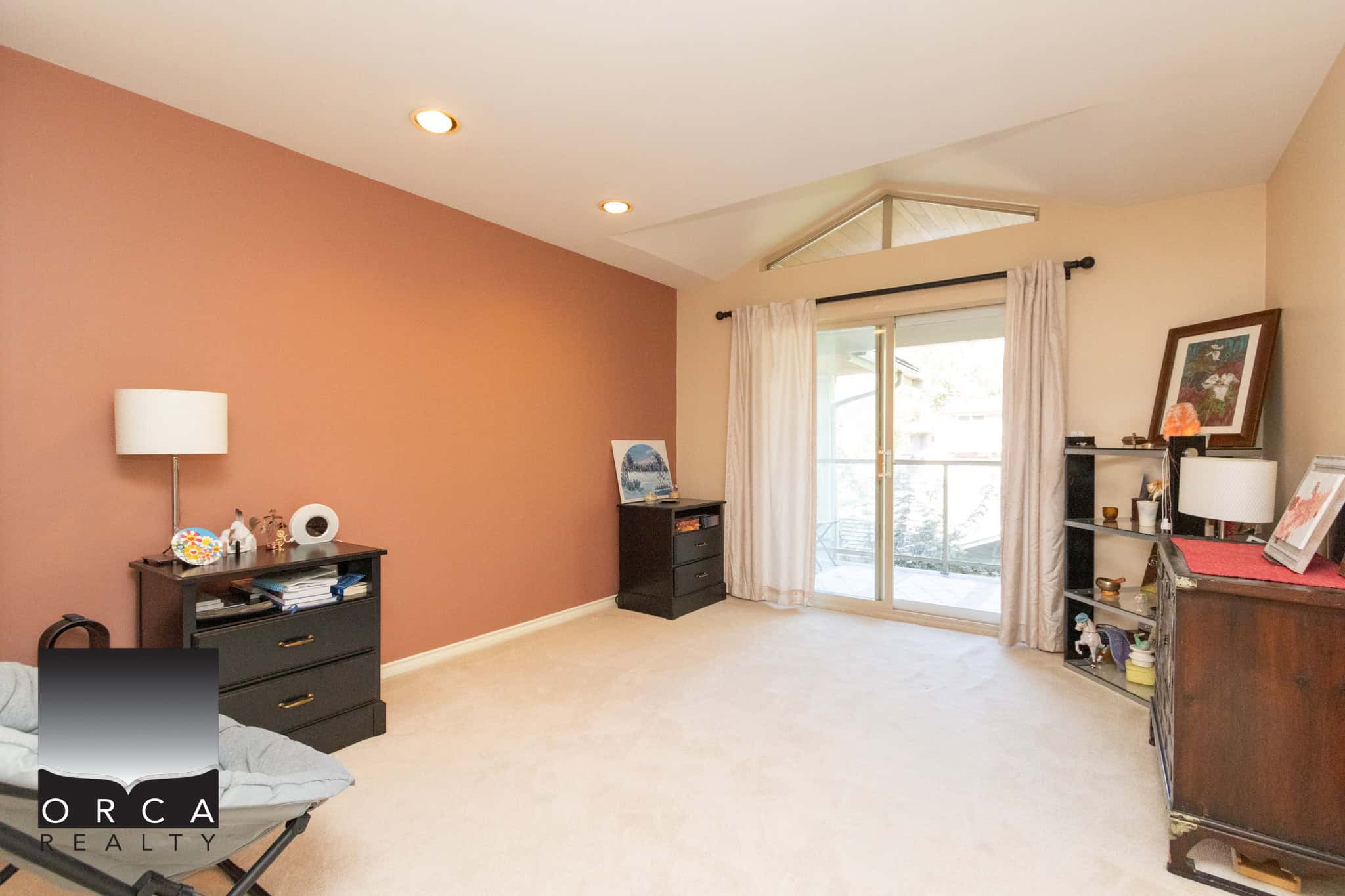 15 Bright living room with large glass sliding door leading to balcony, featuring beige carpet flooring, cozy decor, and ample natural light for a welcoming atmosphere in Vancouver real estate.