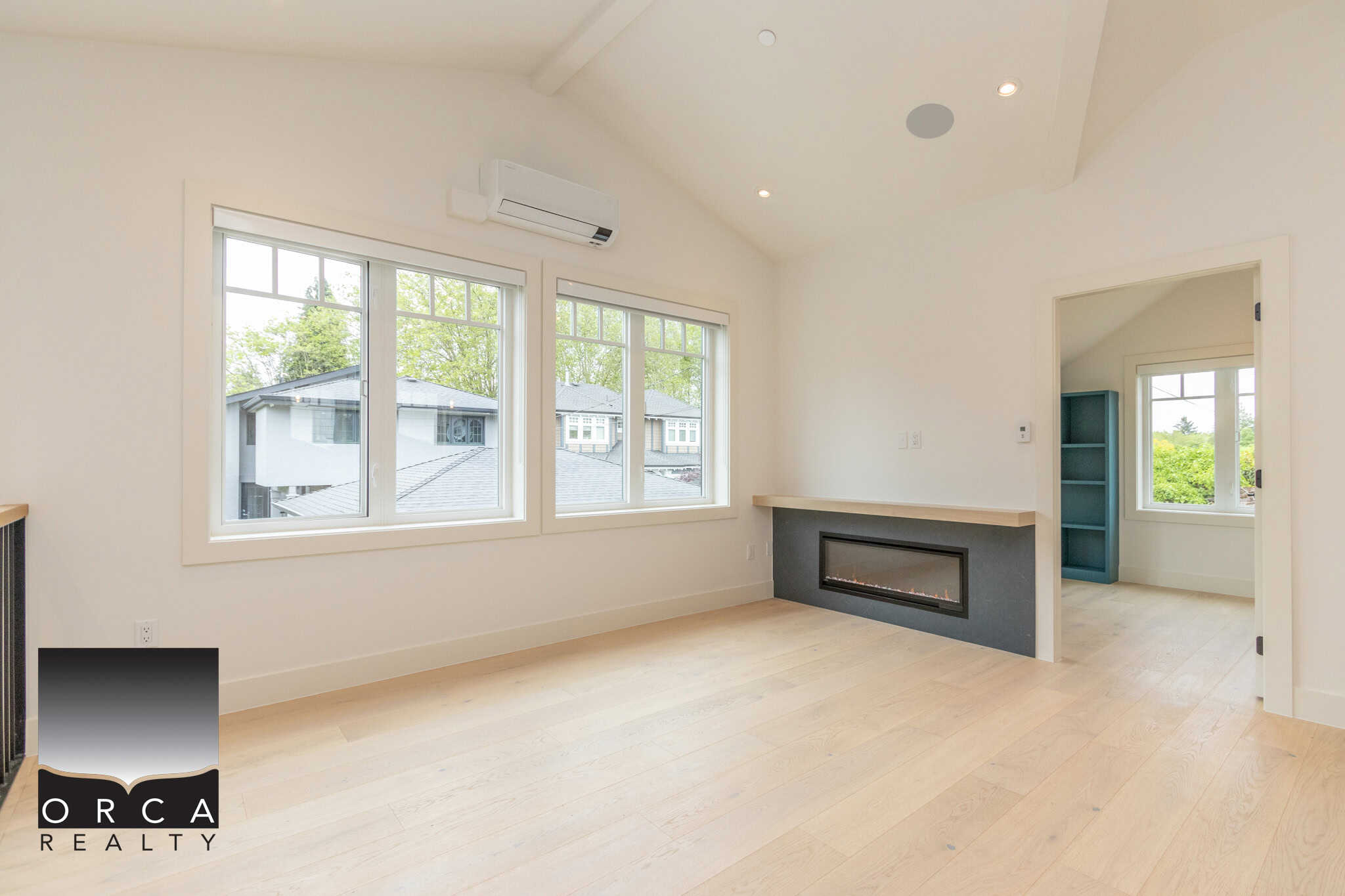 Bright living room with large windows, modern fireplace, and minimalist design, showcasing Vancouver home features by Orca Realty Inc.
