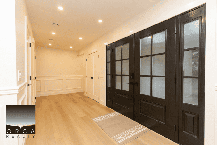 Sliding black glass patio doors in modern home interior|modern home interior with black glass sliding doors and light wood flooring|Bright and spacious home interior featuring stylish black glass sliding patio doors, white walls, and warm wood flooring, perfect for modern living in Canada.|Modern home interior with black glass sliding patio doors, white paneled walls, and light wood flooring, ideal for contemporary residential spaces in Canada.|relevance.