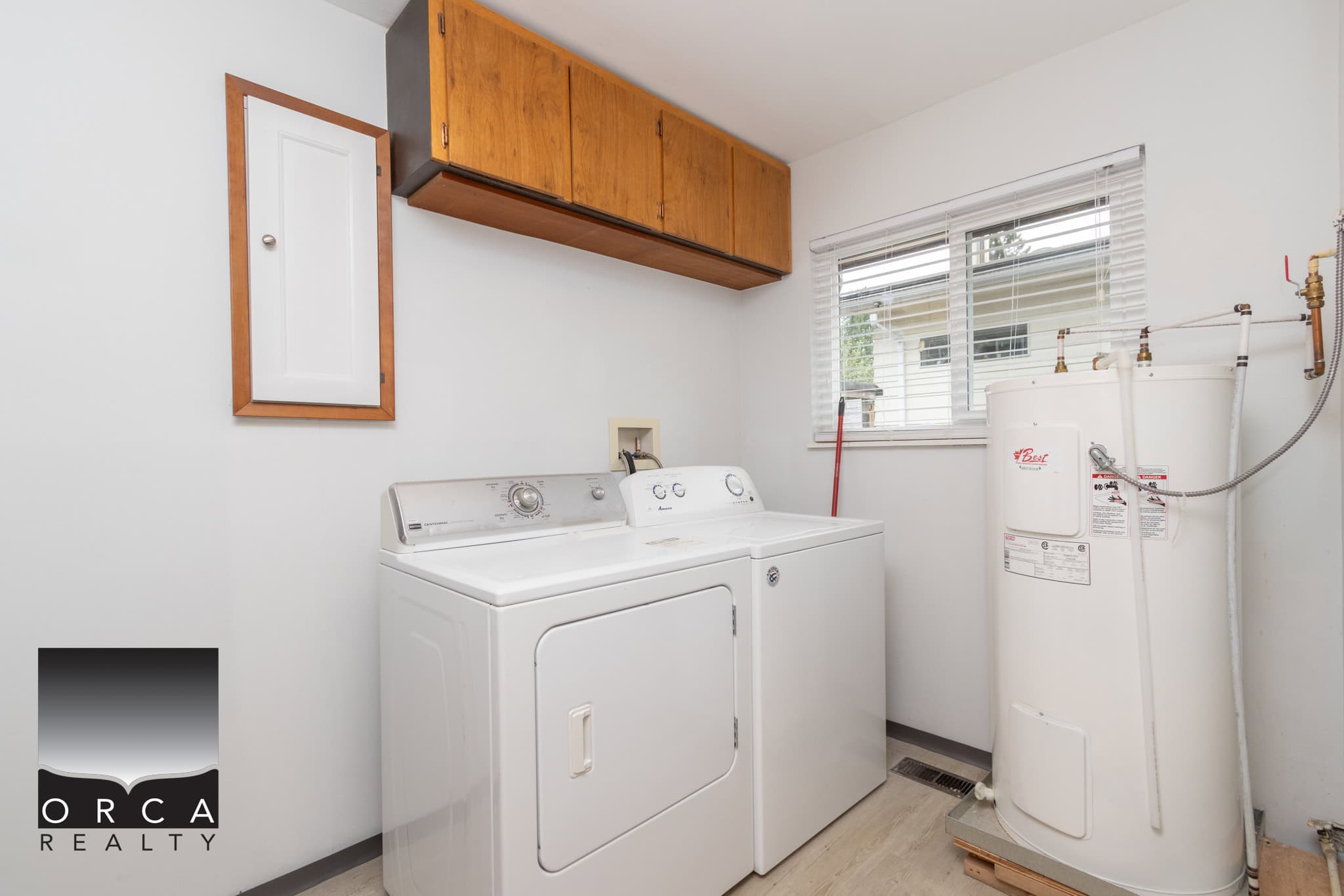 16 Clean laundry room with washer, dryer, water heater, and storage cabinets, perfect for home organization and utility convenience.