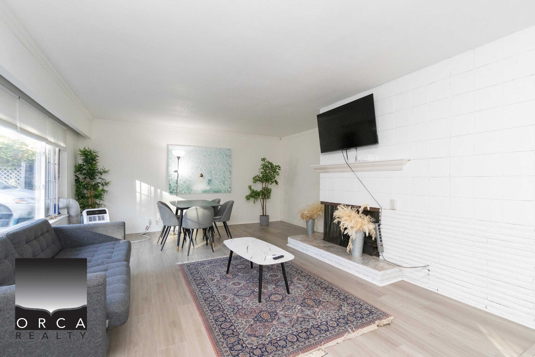 16 Bright living room with modern decor, fireplace, flat-screen TV, and large window, showcasing a spacious and stylish interior perfect for Vancouver real estate opportunities.