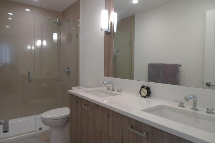 Modern bathroom showcasing double sinks, a walk-in shower, and contemporary fixtures, highlighting Vancouver real estate opportunities with Orca Realty Inc.