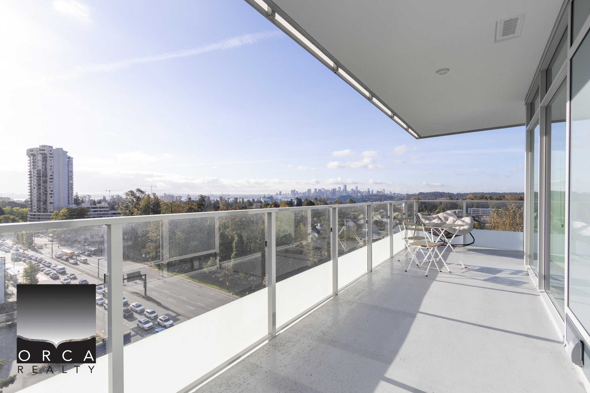 Bright modern condo balcony with panoramic city views and outdoor seating, perfect for Vancouver real estate buyers seeking luxury apartments in the city.