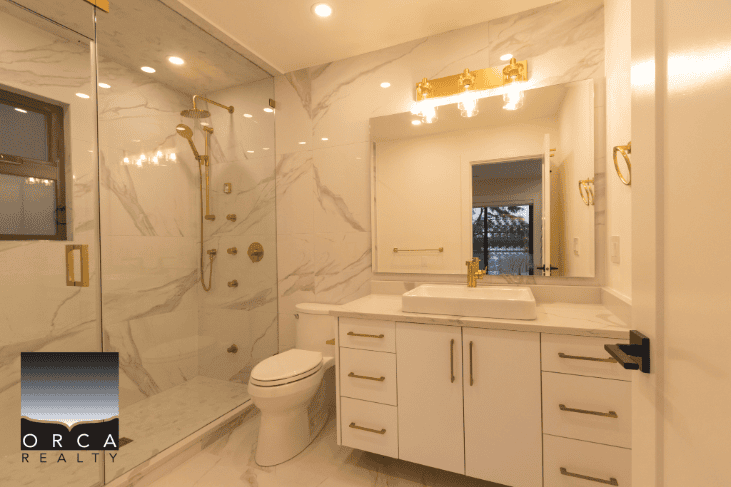 Luxurious modern bathroom with marble finishes, gold fixtures, and a spacious walk-in shower, perfect for upscale Ontario homes.