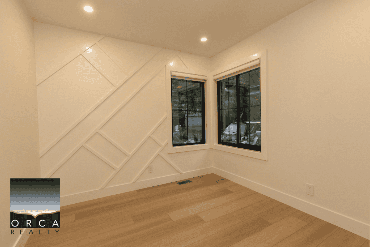 Bright modern interior room with large windows, hardwood flooring, and custom wall design showcasing Vancouver real estate offerings by Orca Realty Inc.