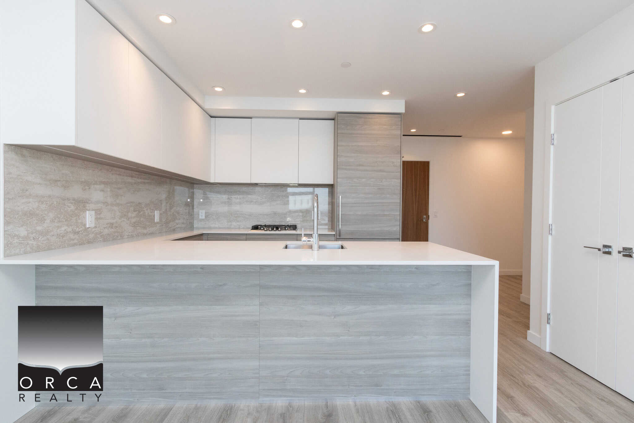 19 Modern minimalist kitchen with sleek white and grey cabinetry, quartz countertops, and stainless steel appliances, showcasing contemporary design ideal for Vancouver-area homes.