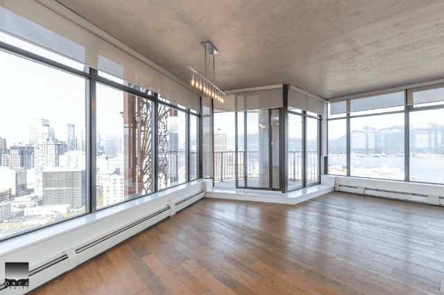 Modern high-rise condominium with panoramic city and waterfront views, spacious open floor plan, large windows, and contemporary design, ideal for Vancouver urban living.