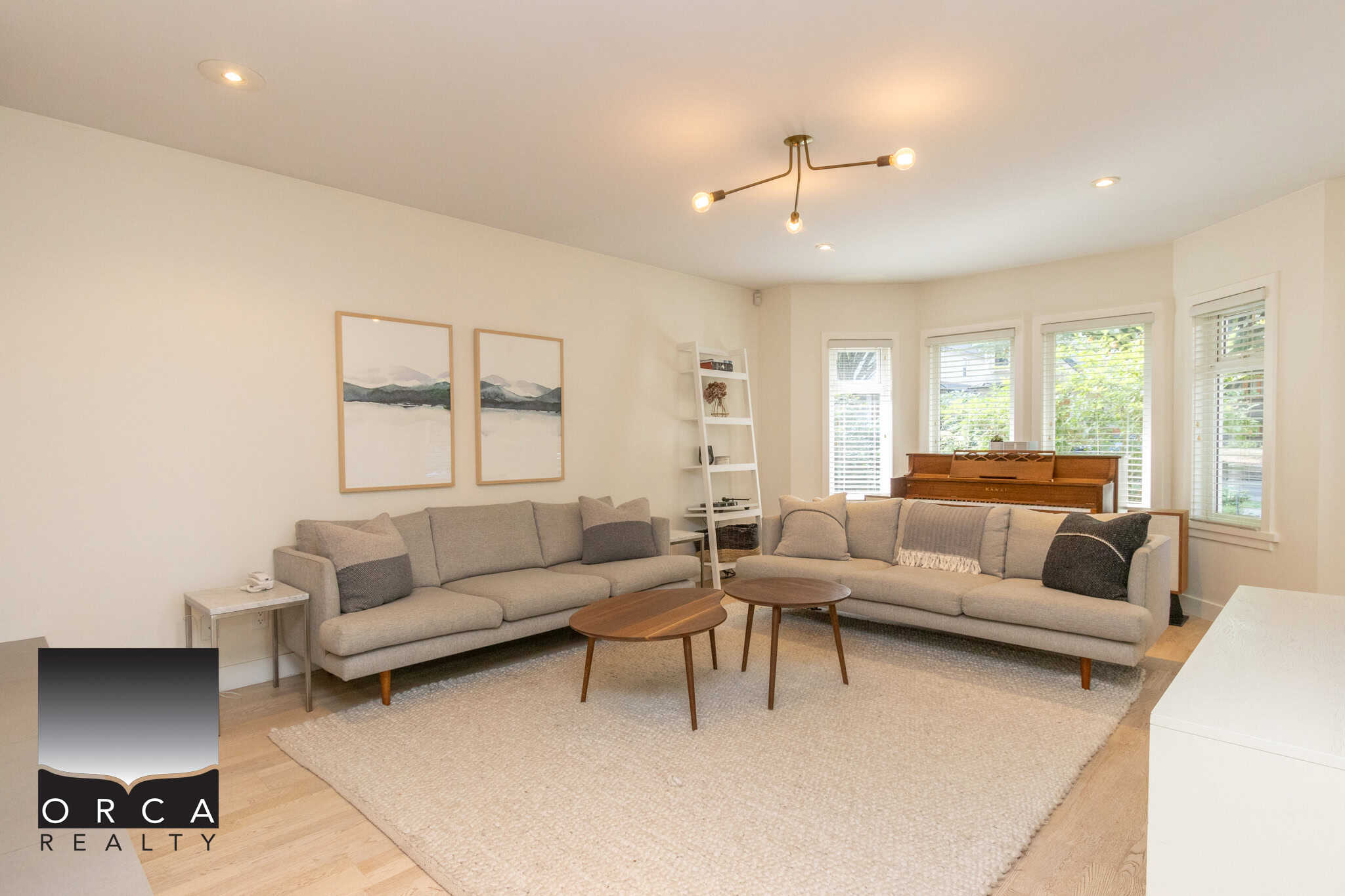 2 Bright and cozy living room featuring modern sofas, a wooden coffee table, and a piano, perfect for family gatherings in a Vancouver-area home listed by Orca Realty Inc.