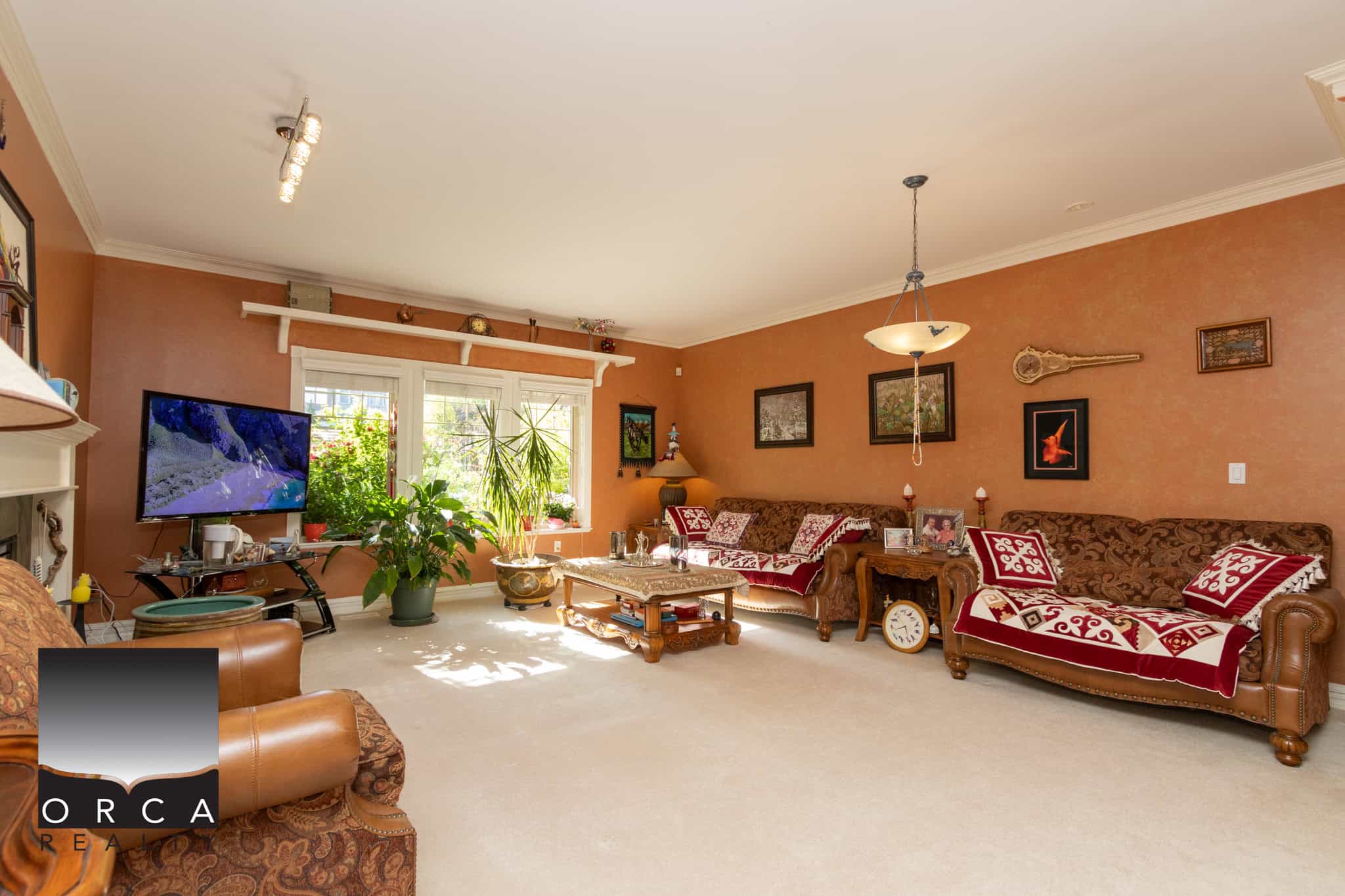 2 Comfortable living room with warm orange walls, vintage furniture, and large window with greenery view, showcasing a cozy home interior ideal for real estate listings.