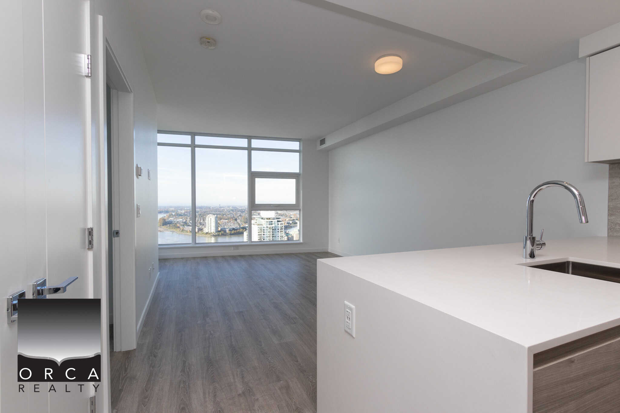2 Stunning modern interior of an upscale apartment in Vancouver with large windows, city views, open kitchen, and contemporary design, available through Orca Realty Inc.