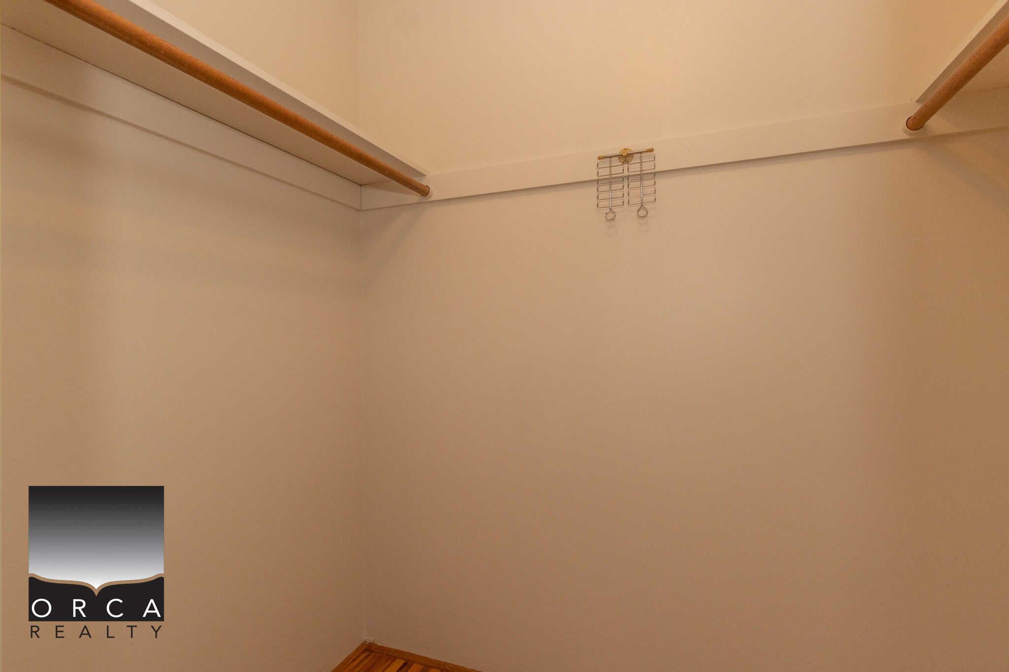 Spacious walk-in closet interior with hanging rods and shelf storage, ideal for Vancouver real estate buyers seeking organized bedroom storage solutions.