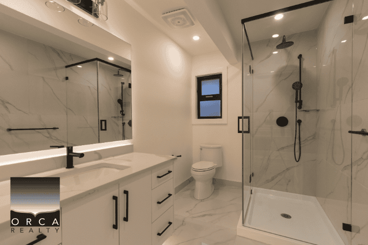 Modern luxury bathroom with marble tiles, walk-in shower, and sleek white cabinetry – ideal for Vancouver Island homes.