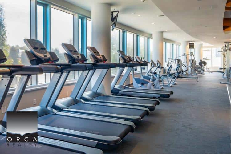 Treadmills and exercise equipment in a modern fitness centre at Orca Realty Inc. building.