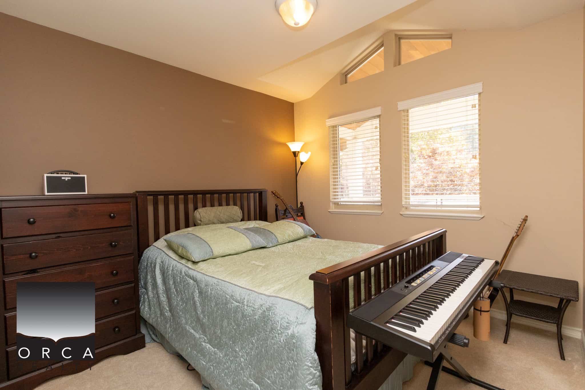 21 Quiet bedroom with large windows, modern furnishings, and a keyboard for home comfort. Ideal for family living with natural light and musical space, perfect for relaxing and entertaining.