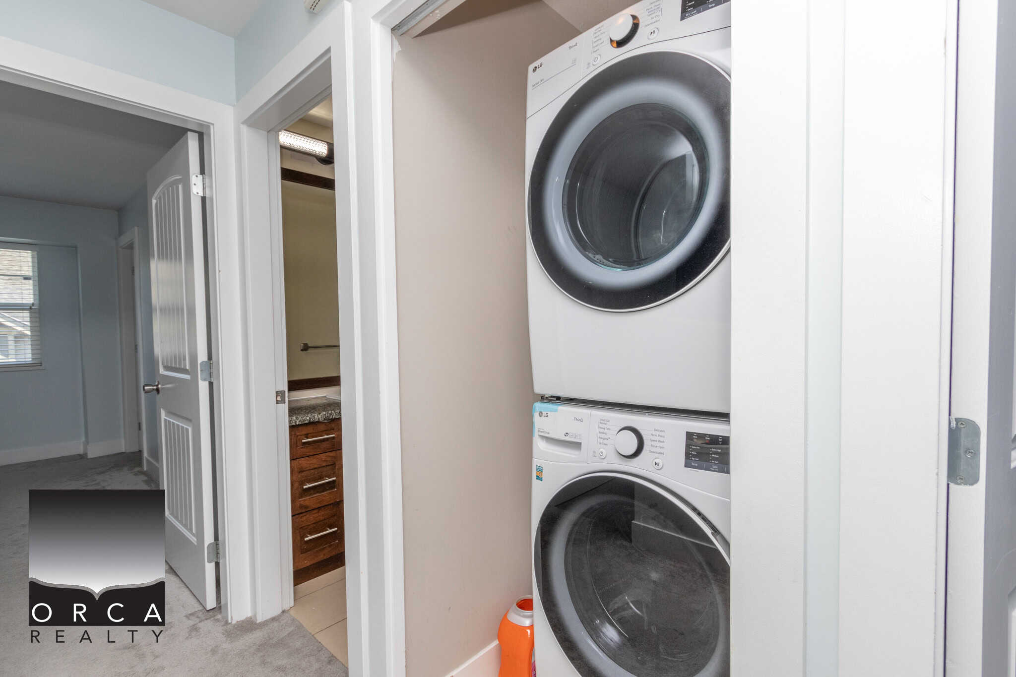 Stacked washer and dryer in a compact laundry closet within a modern home.