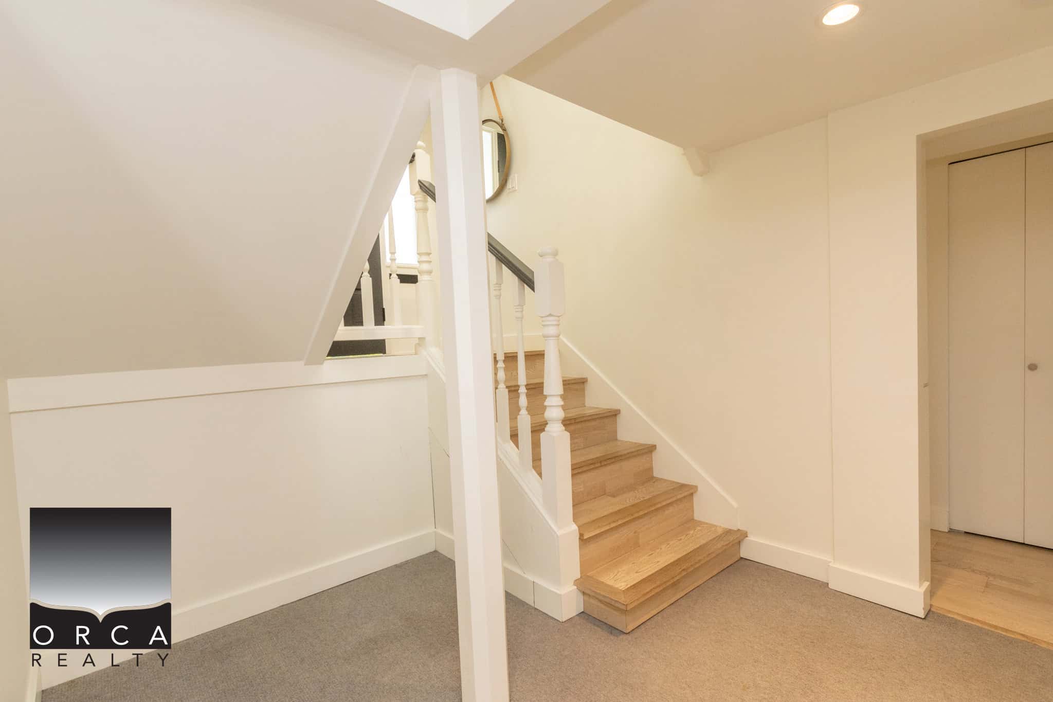 23 Staircase interior of a modern home showcasing clean design, hardwood steps, and white walls, ideal for buyers seeking stylish residential real estate in Vancouver and surrounding areas in BC.